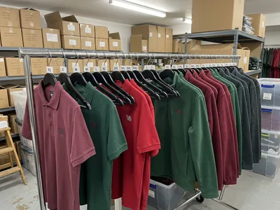A full-size try-on set hanging on a rail in a lead store's stockroom