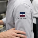 Small flag embroidered on a chef coat sleeve