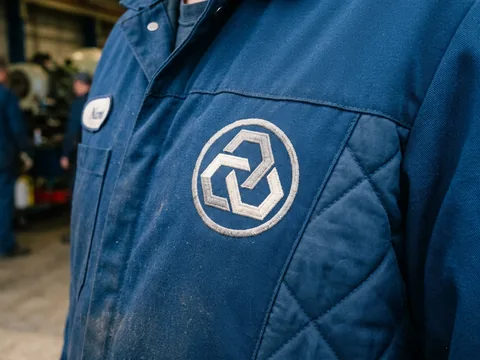 Embroidered logo on the shell panel of an insulated coverall