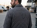 Diamond-quilted jacket back with an unquilted window around the logo