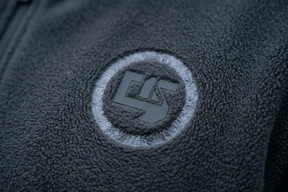 Logo heat-pressed on polar fleece, leaving a crushed shiny outline in the pile