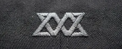 A wordless logo embroidered on poly-cotton twill
