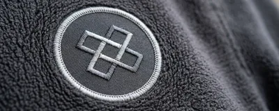The same logo as an embroidered patch sewn onto fleece