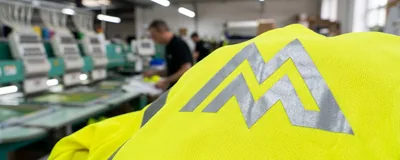The same logo as a silver reflective transfer on a hi-vis knit
